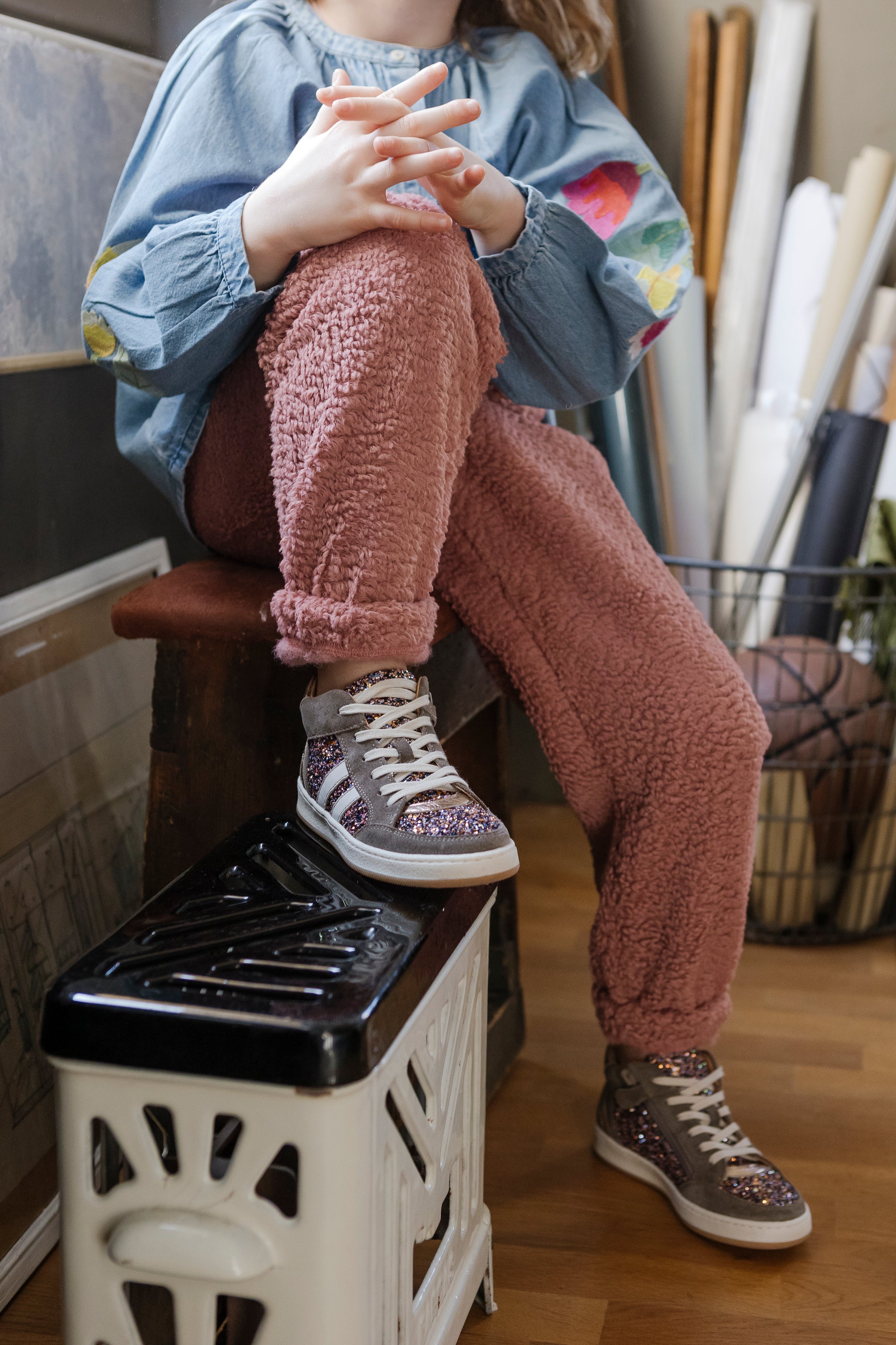 Un enfant assis porte des bottines Babybotte avec glitter
