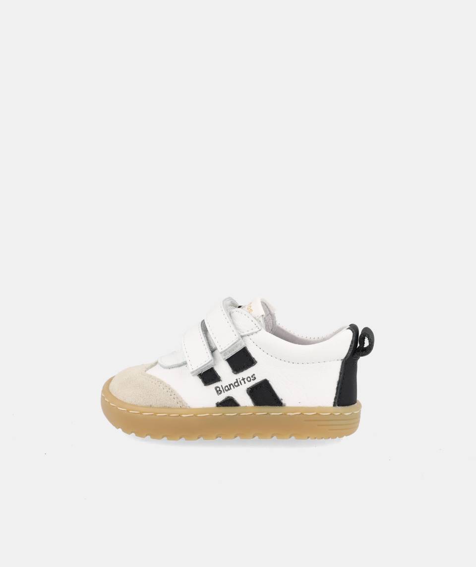 chaussure blanche avec bandes noires, inscription Blanditos sur le côté et semelle épaisse brune.