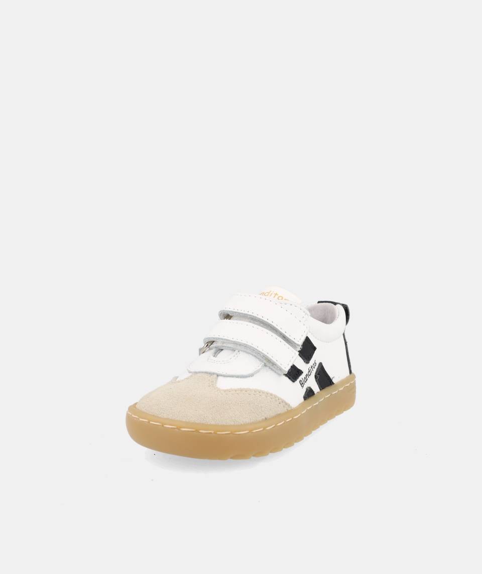 chaussure blanche avec bandes noires, inscription Blanditos sur le côté et semelle épaisse brune.