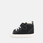 chaussure montante noire avec velcro, lacets élastiques blancs et semelle blanche