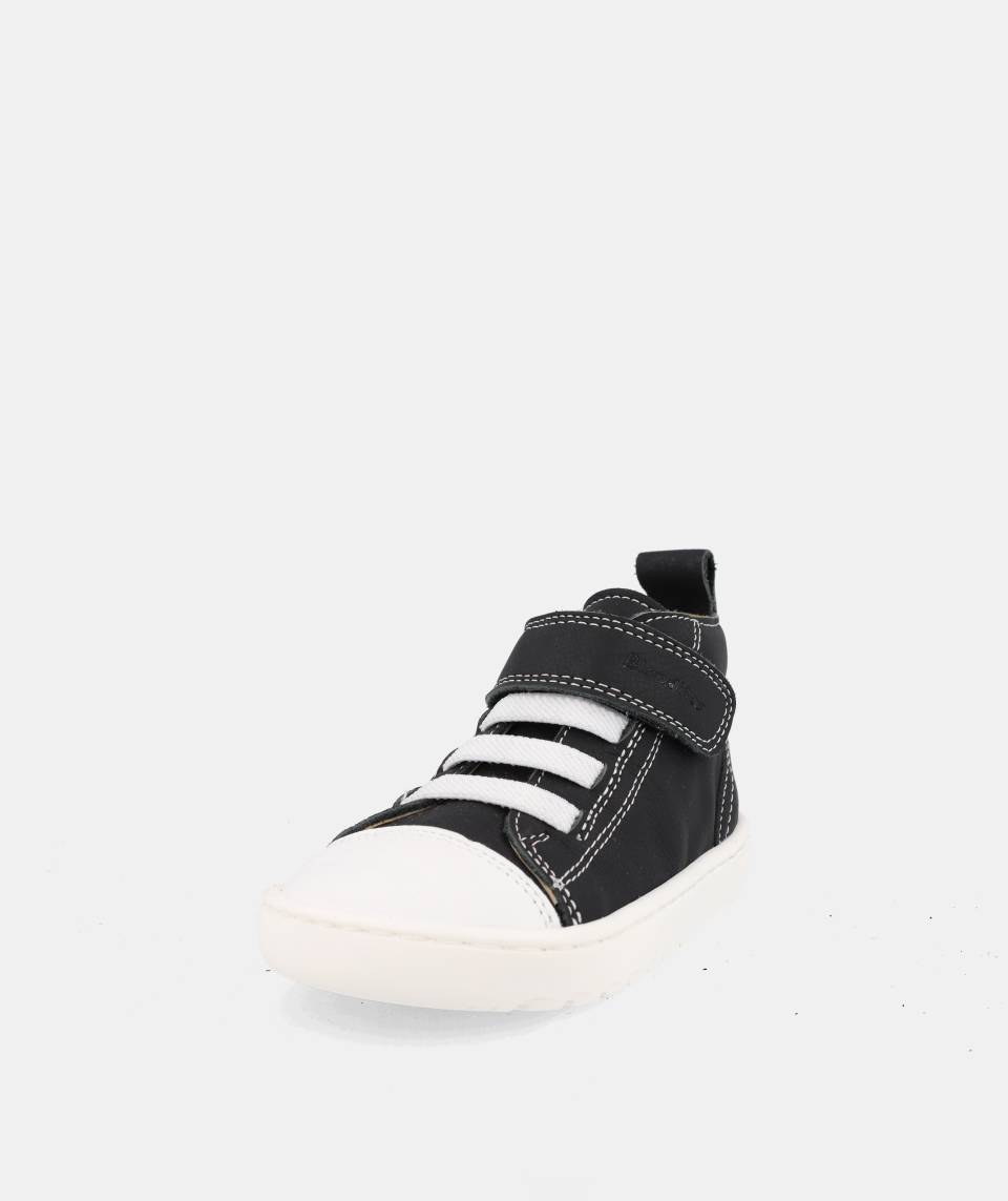 chaussure montante noire avec velcro, lacets élastiques blancs et semelle blanche