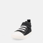 chaussure montante noire avec velcro, lacets élastiques blancs et semelle blanche