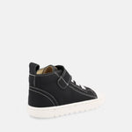 chaussure montante noire avec velcro, lacets élastiques blancs et semelle blanche