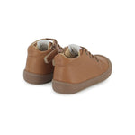 Chaussure premiers-pas pour bébé Pom d'Api en cuir nappa brun, avec des lacets élastiques.