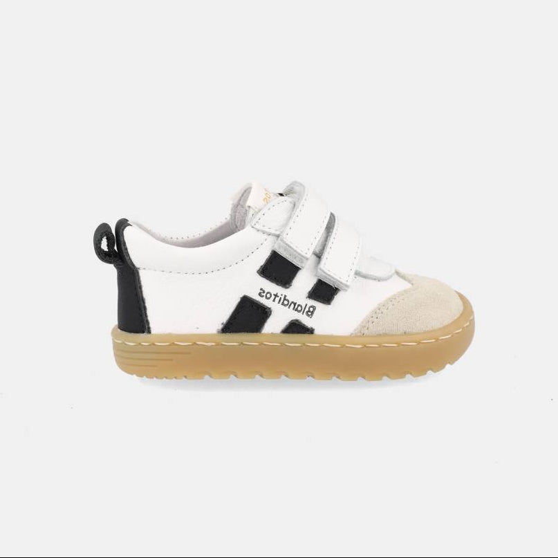 chaussure blanche avec bandes noires, inscription Blanditos sur le côté et semelle épaisse brune.