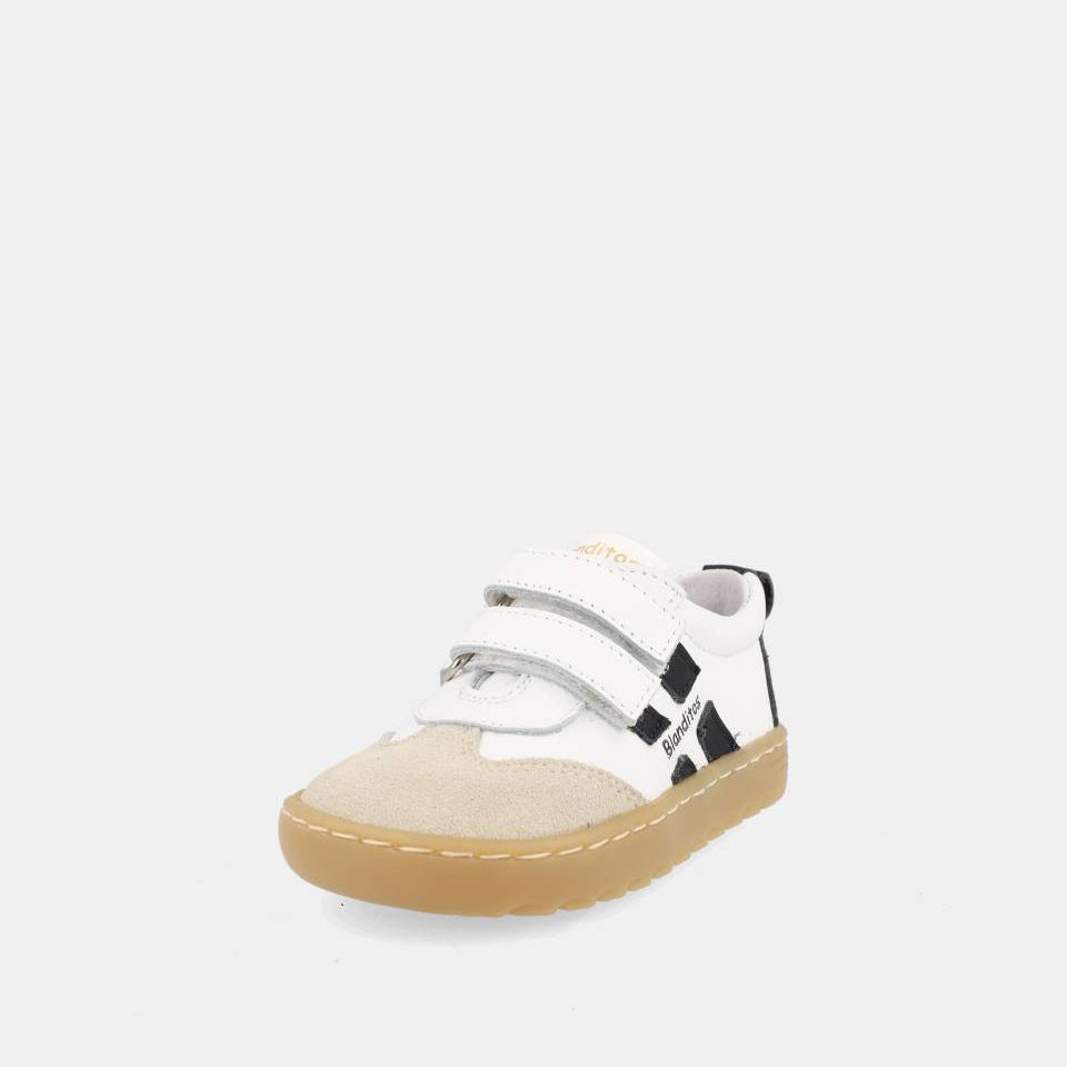 chaussure blanche avec bandes noires, inscription Blanditos sur le côté et semelle épaisse brune.