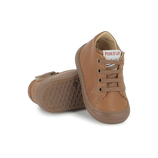 Chaussure premiers-pas pour bébé Pom d'Api en cuir nappa brun, avec des lacets élastiques.