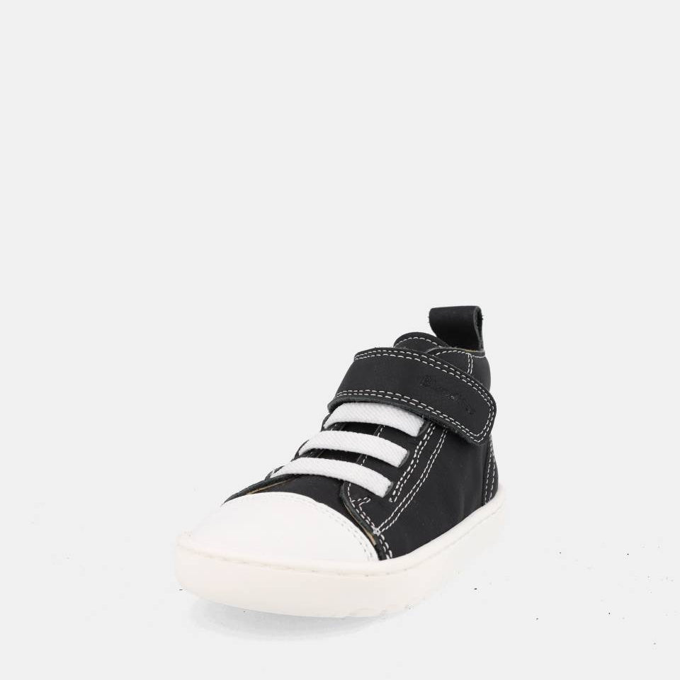 chaussure montante noire avec velcro, lacets élastiques blancs et semelle blanche