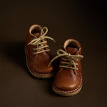 Chaussures danoise pour enfant de Petit Nord, couleur cognac, avec lacet beige, look vintage.
