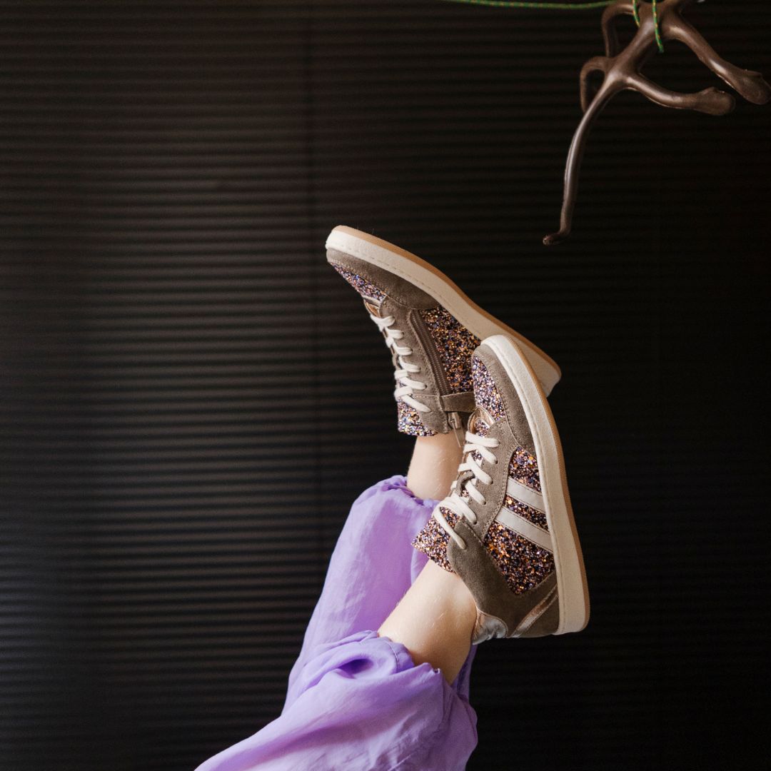 Fille chaussée avec les sneakers Babybotte Kolyne couleur brune et mauve brillant.