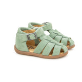 Sandale souple en cuir pour les premiers pas des enfants dans un beau vert, avec attache velcro sous la boucle. 