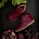Chaussure Petit Nord pour enfant couleur Fuschia  avec velcro, à côté d'une Pomme grenade de la même couleur. 
