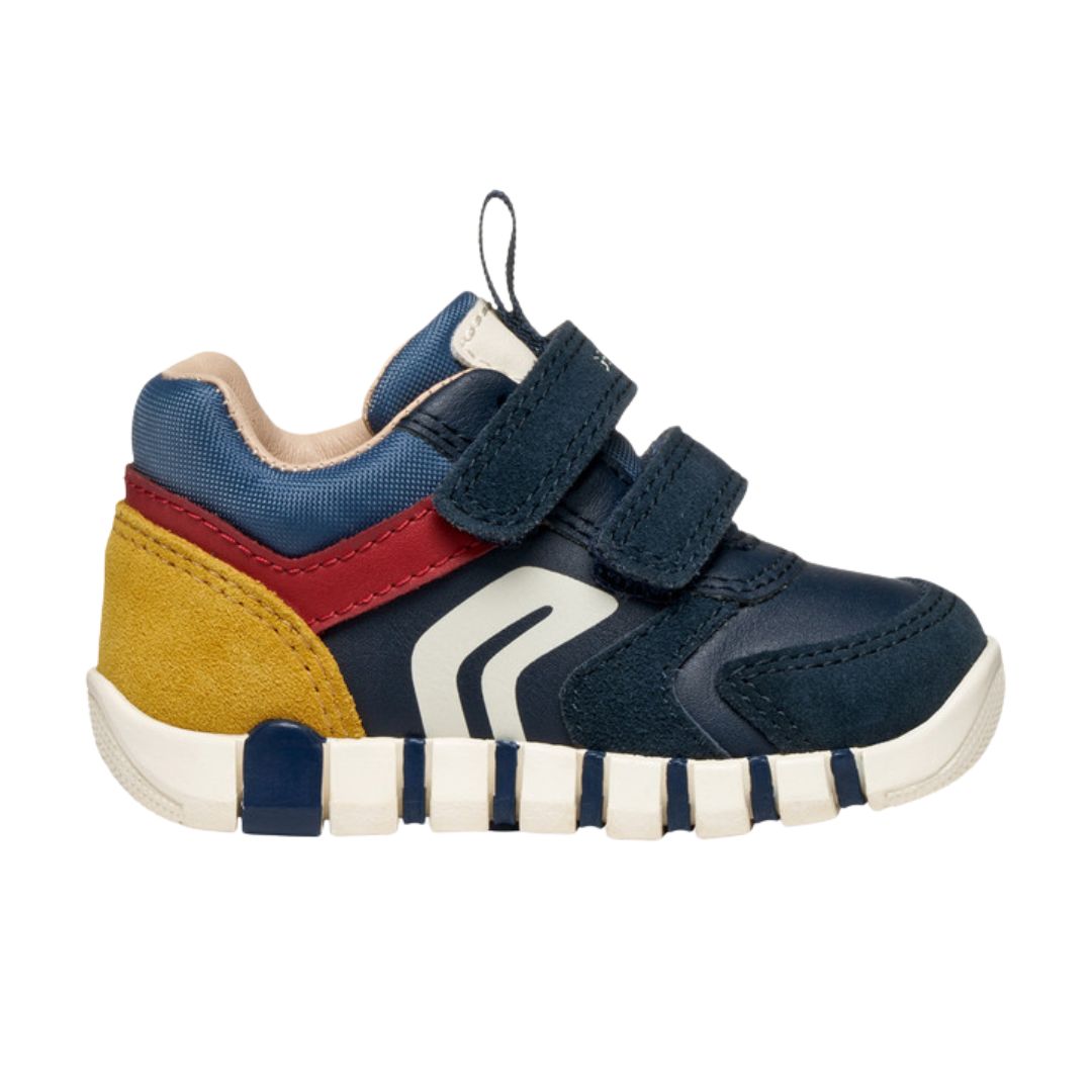 chaussure bébé en bi-matière bleu foncé, rouge et jaune, avec motifs rayures sur la semelle et fermeture à velcro.