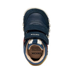 chaussure enfant en bi-matière bleu foncé, rouge et jaune, avec motifs rayures sur la semelle et fermeture à velcro.