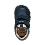 chaussure enfant en bi-matière bleu foncé, rouge et jaune, avec motifs rayures sur la semelle et fermeture à velcro.